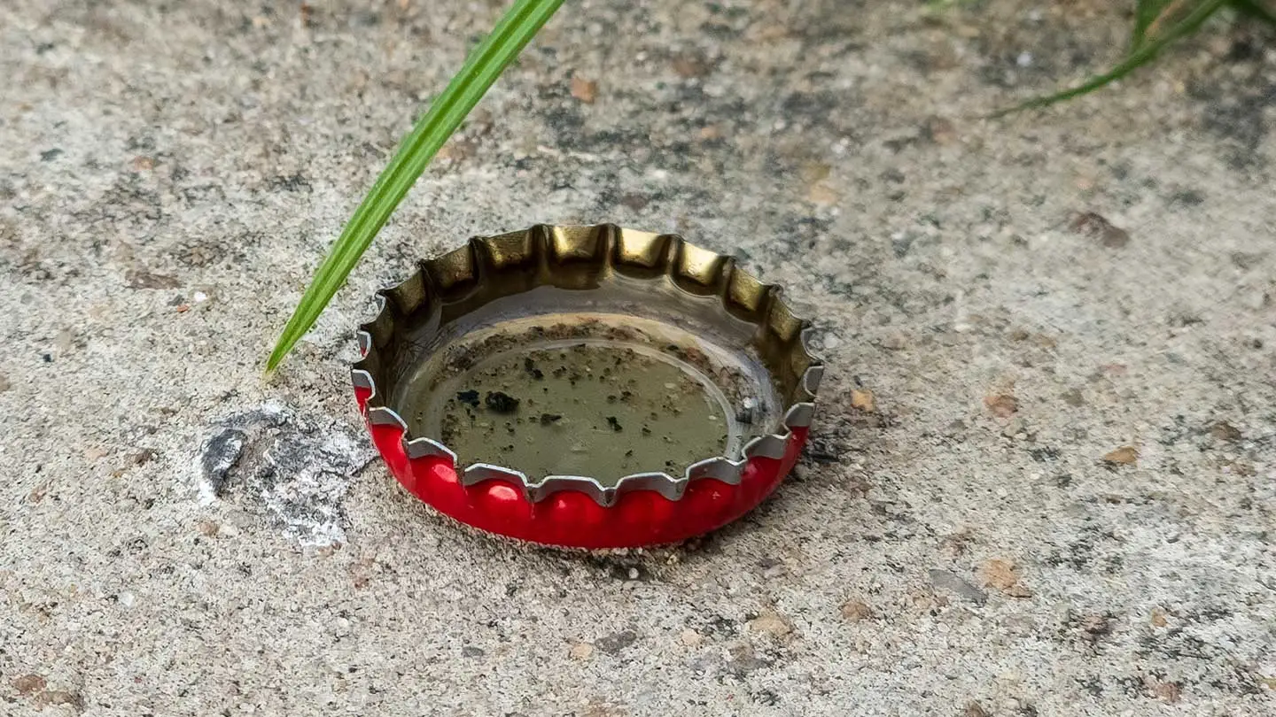 Mosquitos that carry dengue lay their eggs in open water sources, such as this bottle cap that was left outside and filled with water. Residents in Ecuador say that the government should provide amenities, such as trash pickup, to prevent disease transmission